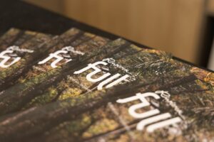 Revistas da Riviera Full organizadas sobre uma mesa, com capa que mostra paisagem da Riviera de São Lourenço.