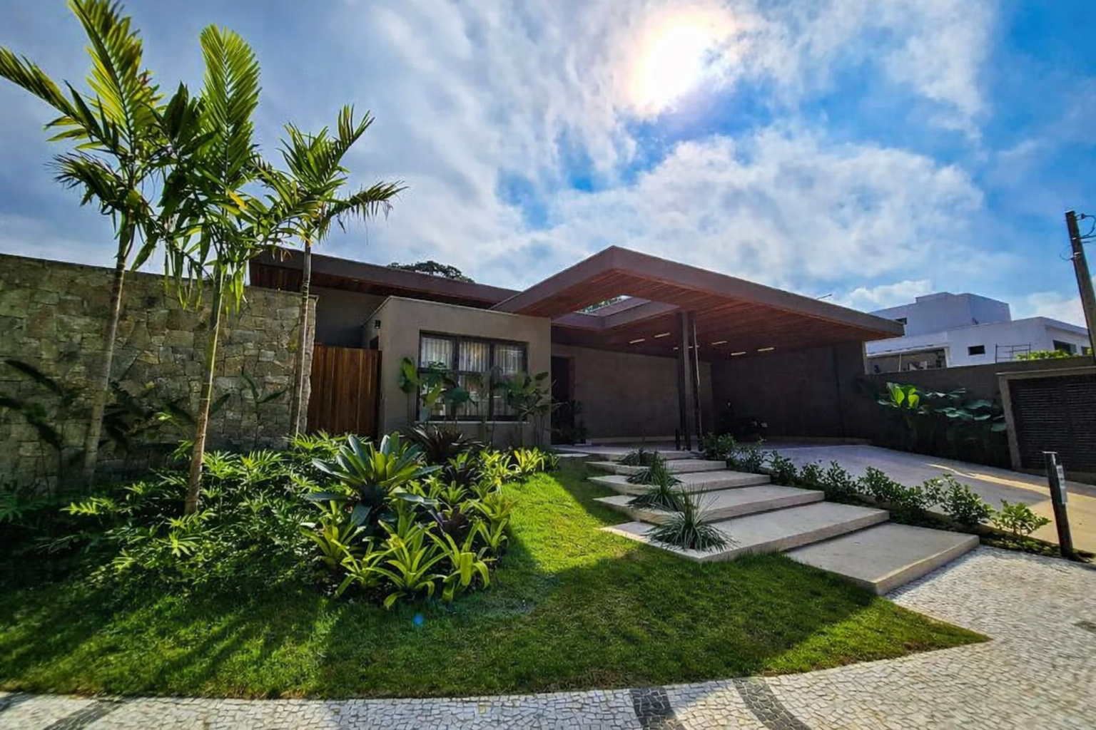Casa moderna térrea com jardim e paisagismo tropical.